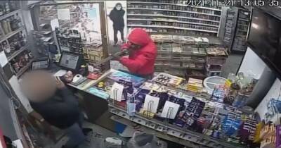 Armed with a shotgun and a knife, this is the terrifying moment two masked men raided an off-licence
